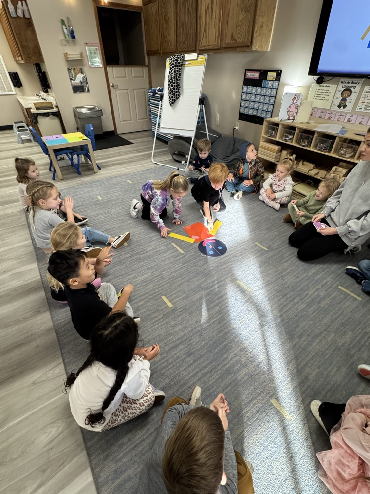 children placing paper body parts to build a person