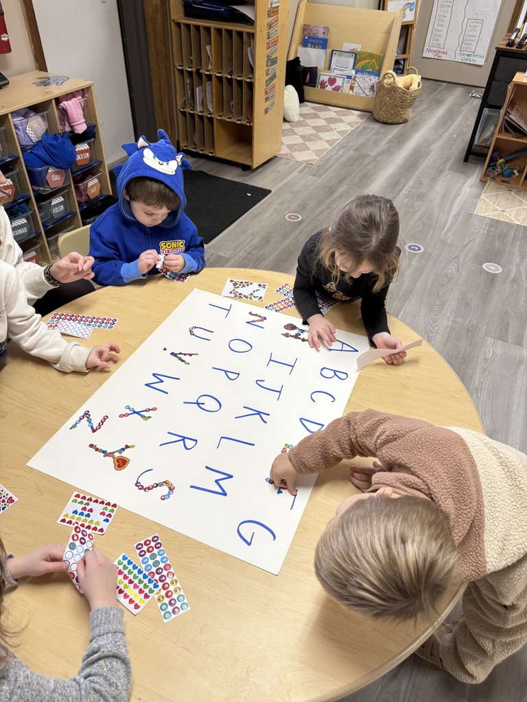 children placing stickers on letters