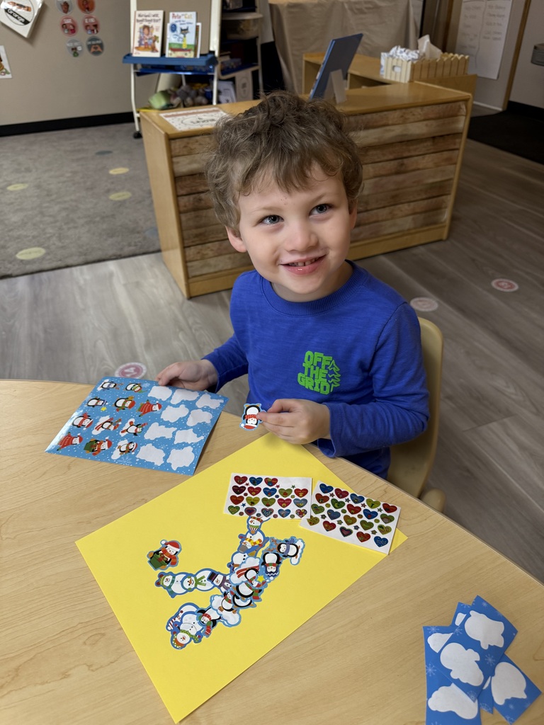 child placing stickers on letter