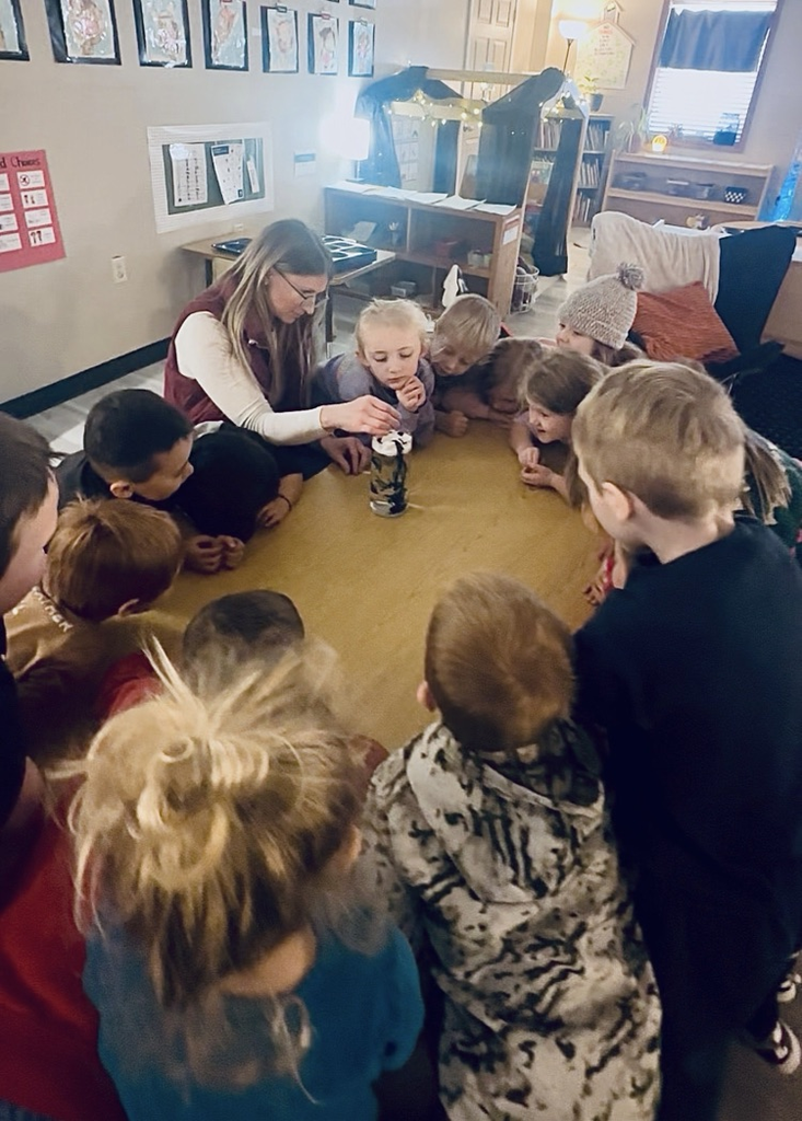 children observing a science experiment about rain