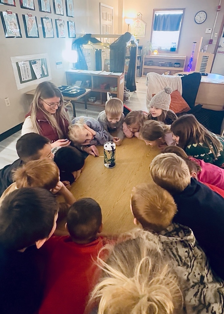 children observing a science experiment about rain