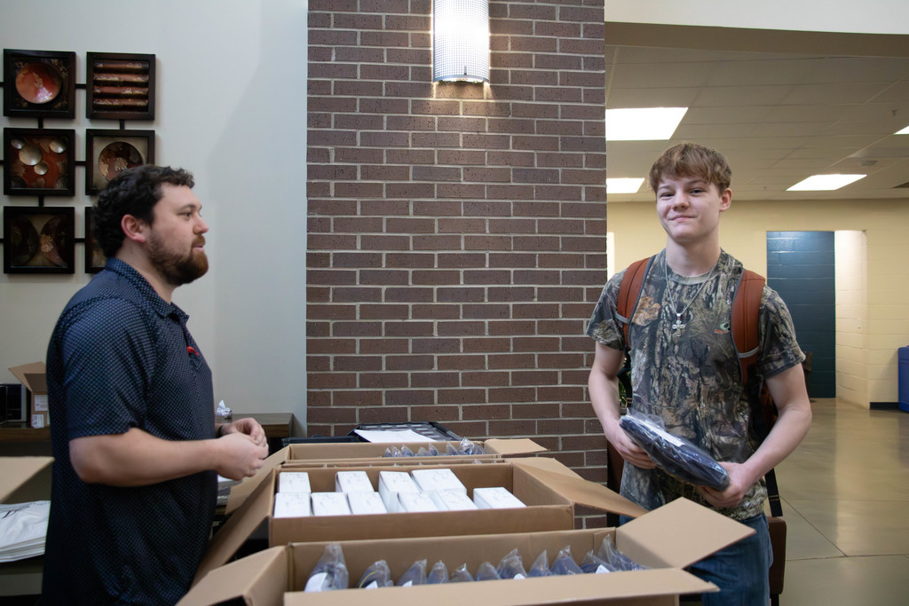 Man and senior holding cap and gown