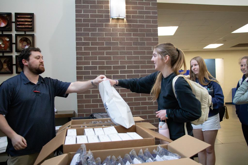 Man handing bag to senior girl