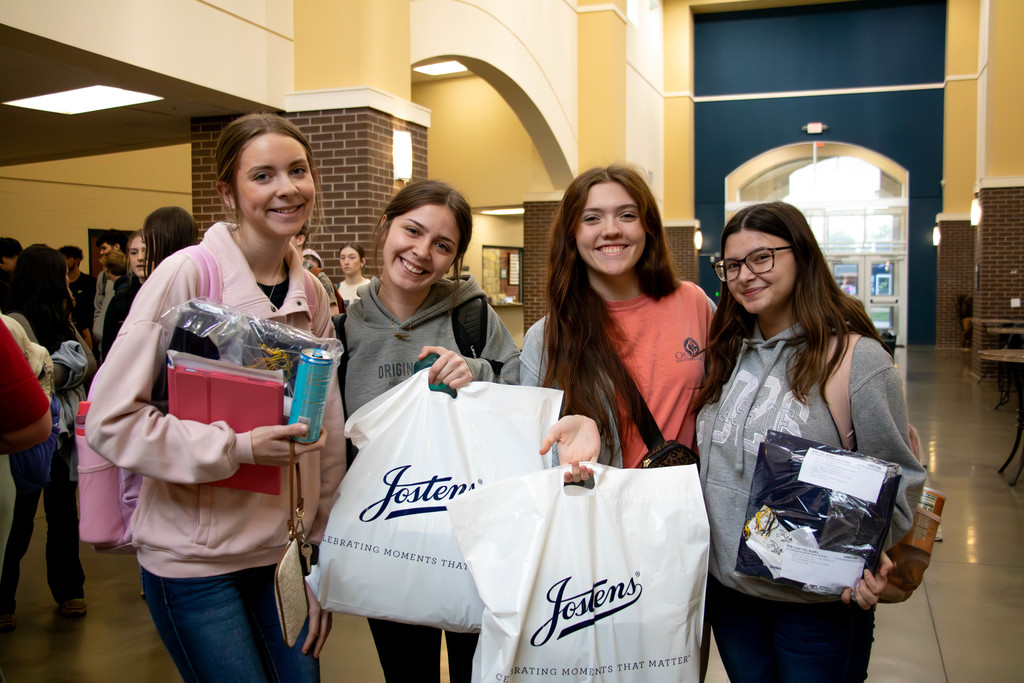 Four senior girls holding bags