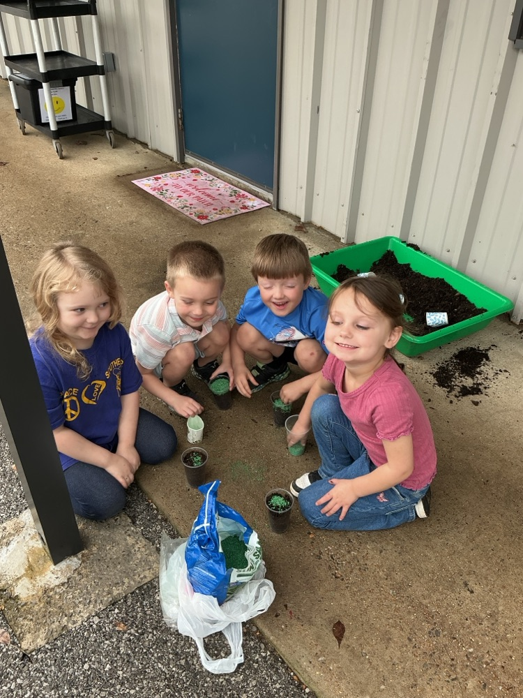 children planting grass seeds