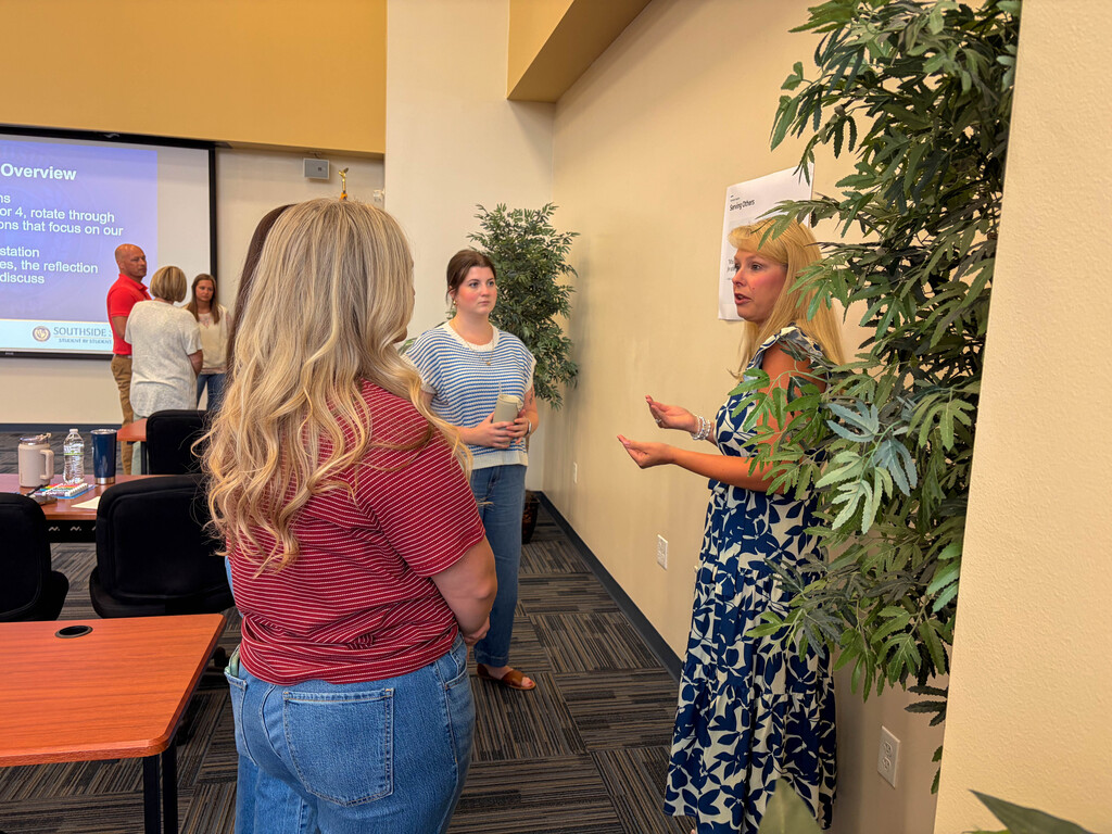 a woman speaking to a small group of teachers