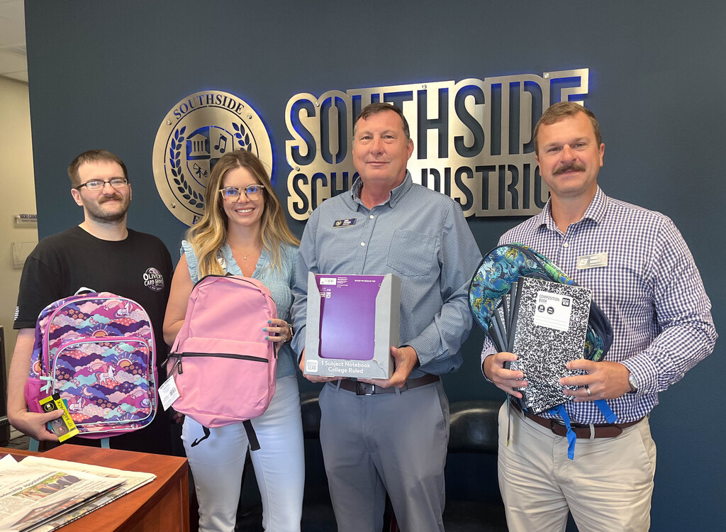 smiling group of men and woman holding school supplies
