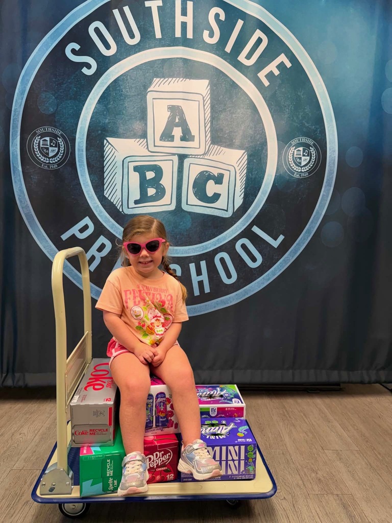 smiling child sitting on cases of drinks