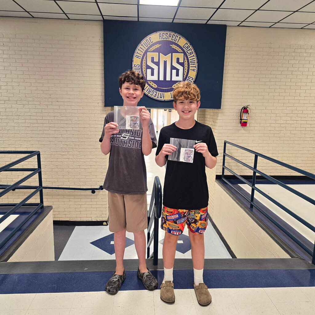 student holding baseball card