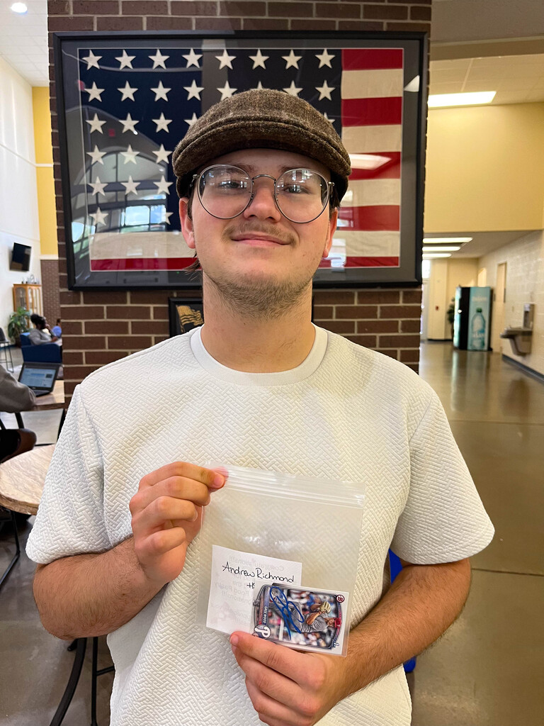 student holding baseball card