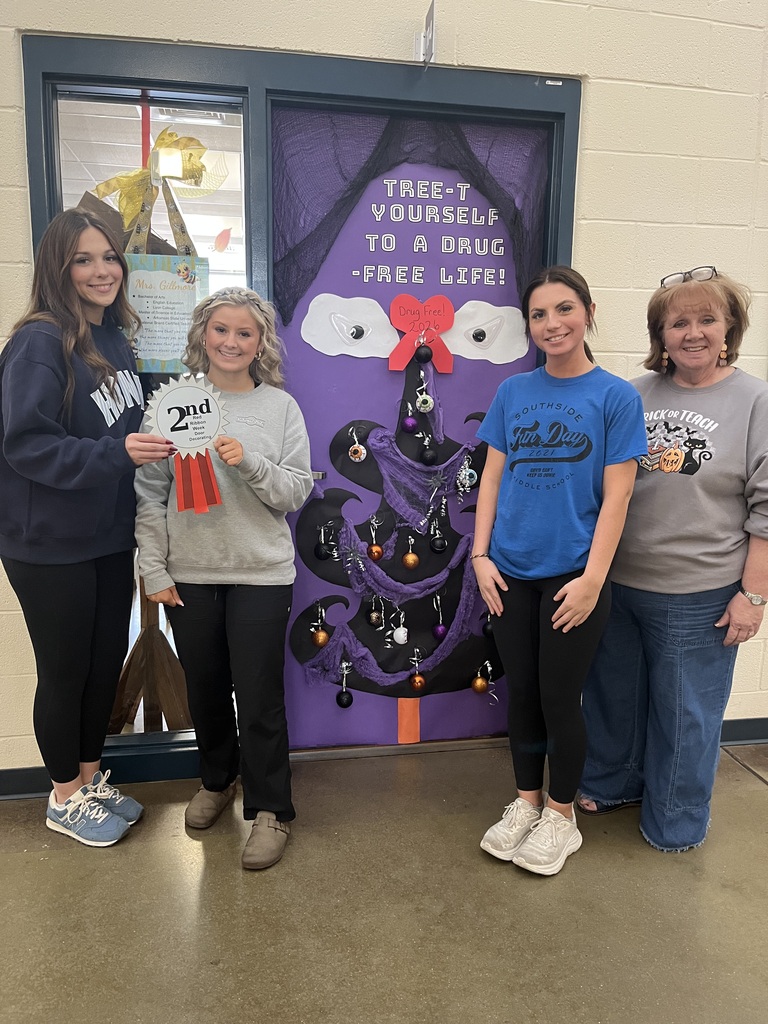 students and teacher smiling,  2nd place door