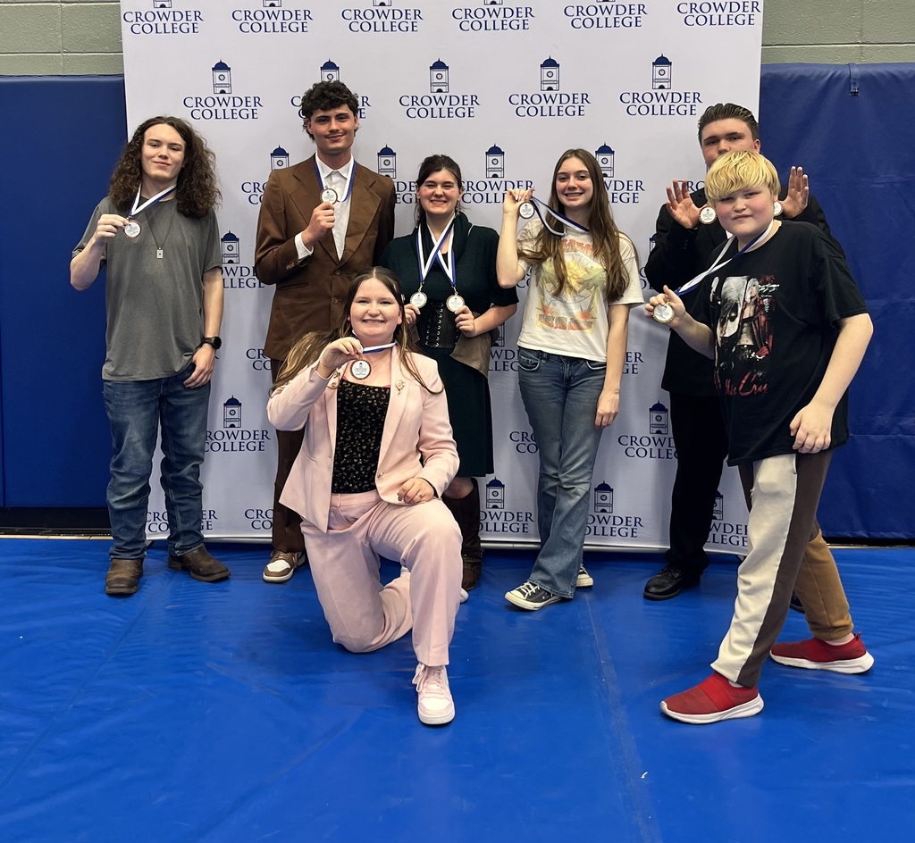 7 students displaying their medals won at the Crowder College Business Contest
