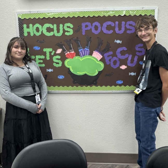 TP students stand next to their October bulletin board 