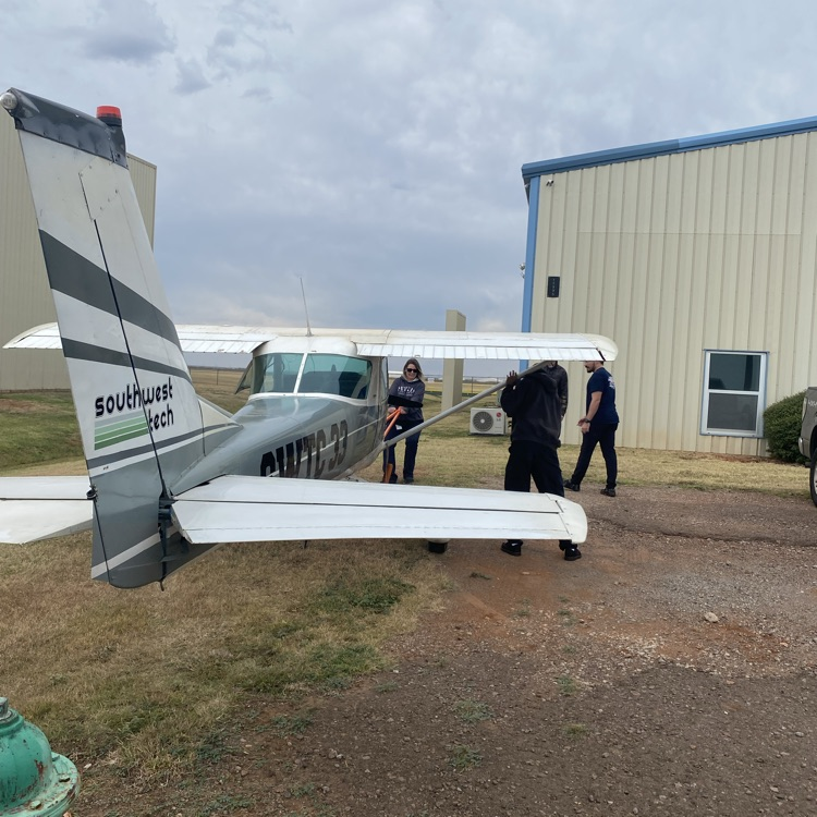 students hand towing a Cessna 150