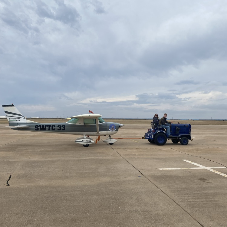 students moving a modified Cessna 150 with a tug