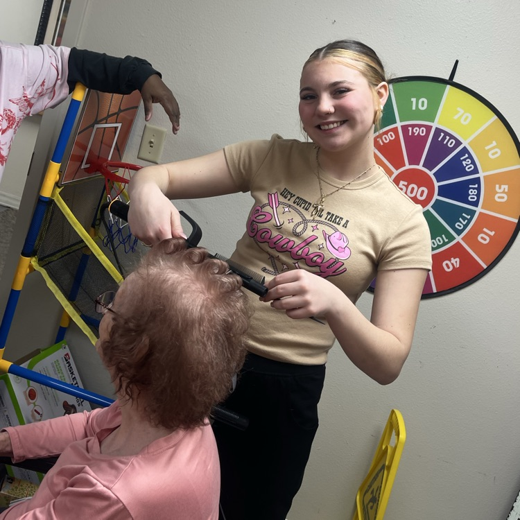 young woman curling elderly woman’s hair