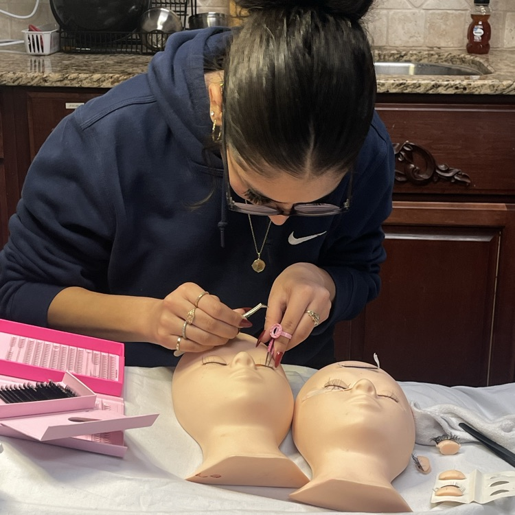 students doing lashes on face mannequin 