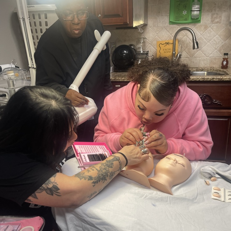 students doing lashes on face mannequin 