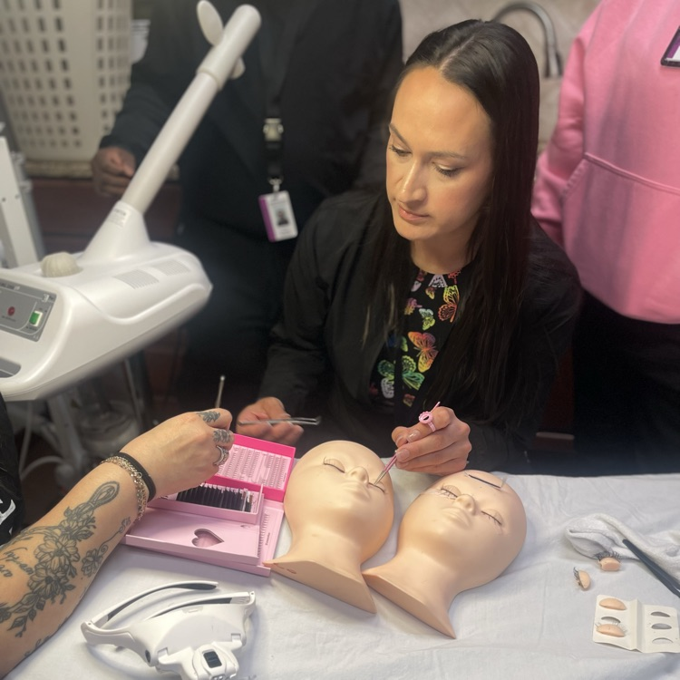 students doing lashes on face mannequin 