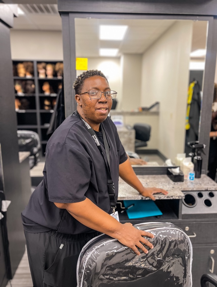 smiling woman standing beside salon chair 
