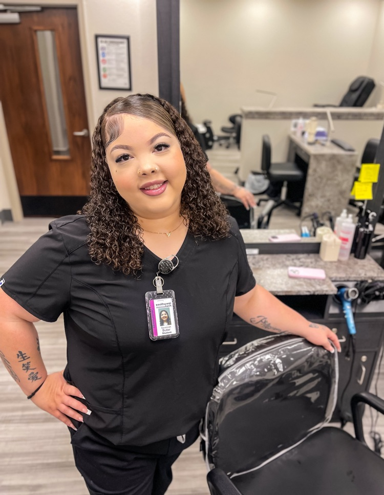 smiling woman standing beside salon chair 