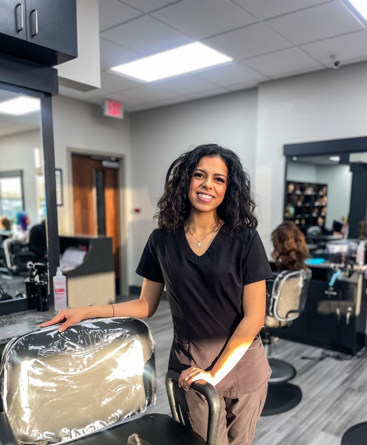 smiling woman standing beside salon chair 
