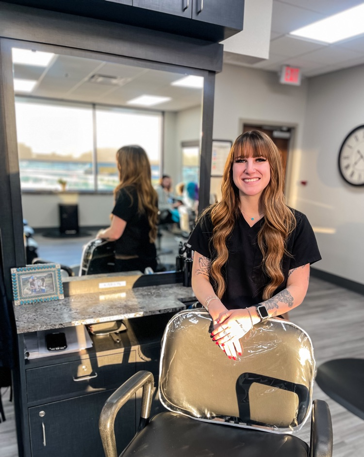 smiling woman standing beside salon chair 