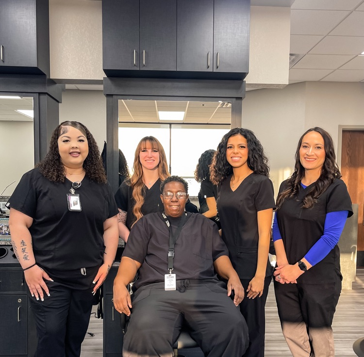 group photo of 5 smiling, adult, cosmetology students 
