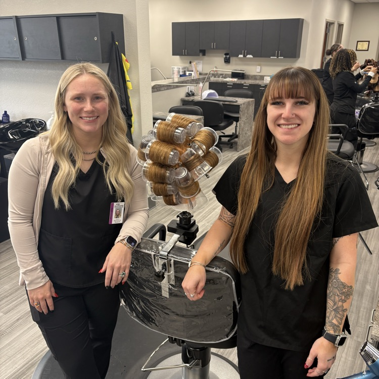 young women standing next to head full of plastic cups 