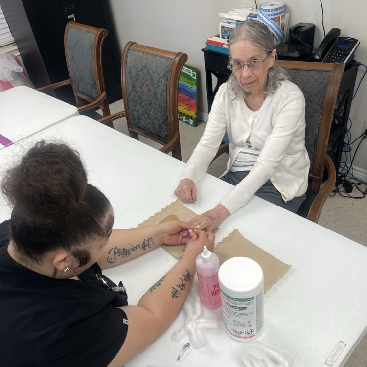 Cosmo students painting resident’s hand