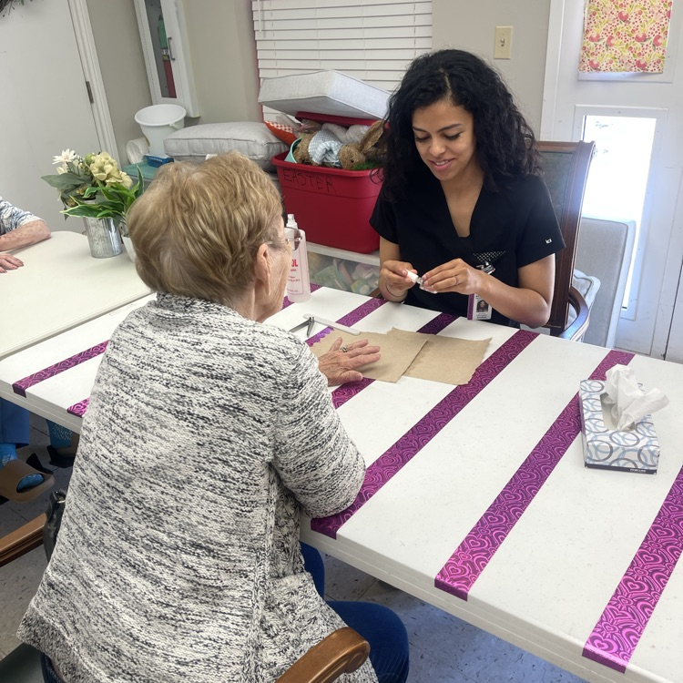 Cosmo student painting resident’s hand