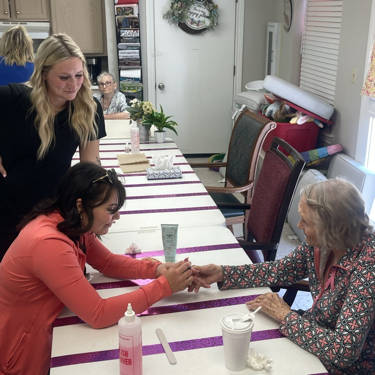 Cosmo student painting resident’s hand