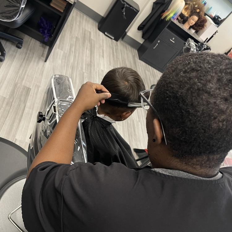 Cosmo student giving boy’s haircut