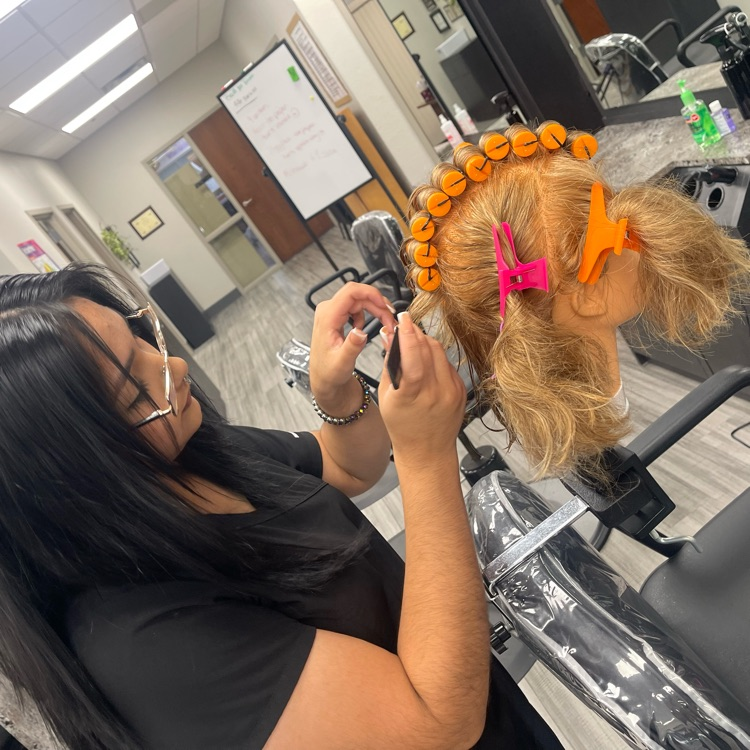 cosmetology student doing perm on mannequin head