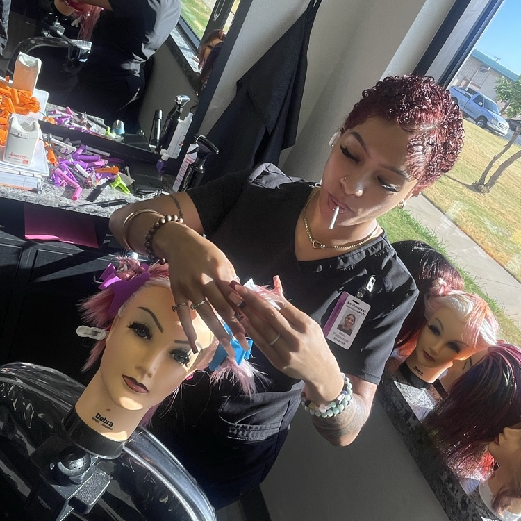 cosmetology student doing perm on mannequin hea