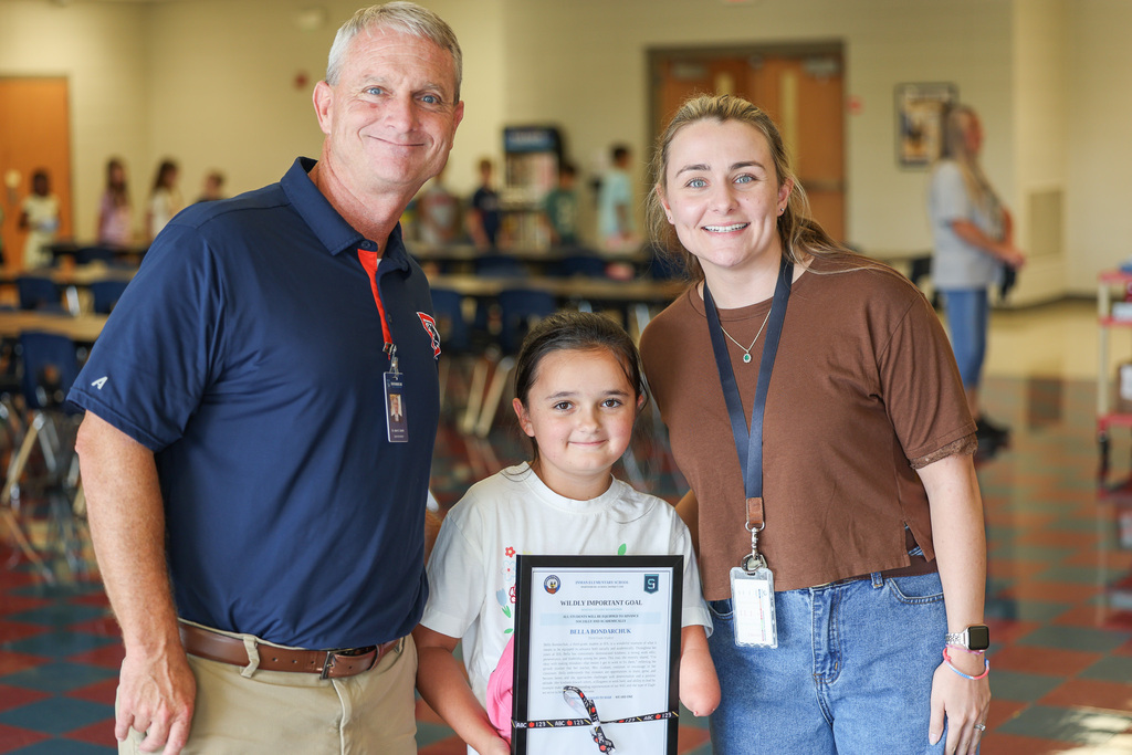 Bella with her teacher and superintendent