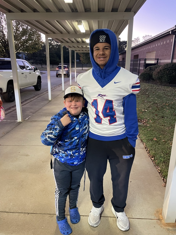 BHS football players greet students in the car line!