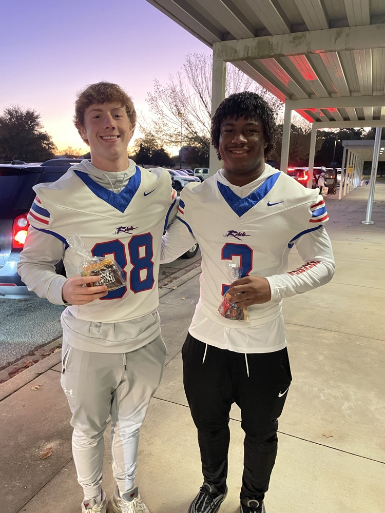 BHS football players greet students in the car line!