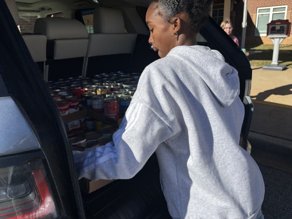 students loading canned food donations for delivery