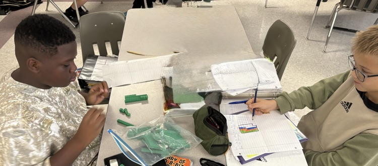 students dividing decimals using base ten blocks to regroup whole numbers into tenths and hundredths