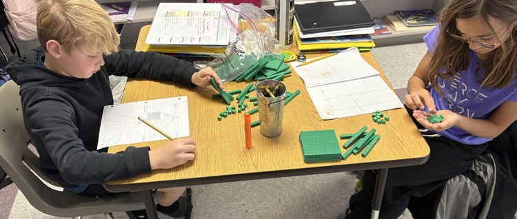 students dividing decimals using base ten blocks to regroup whole numbers into tenths and hundredths