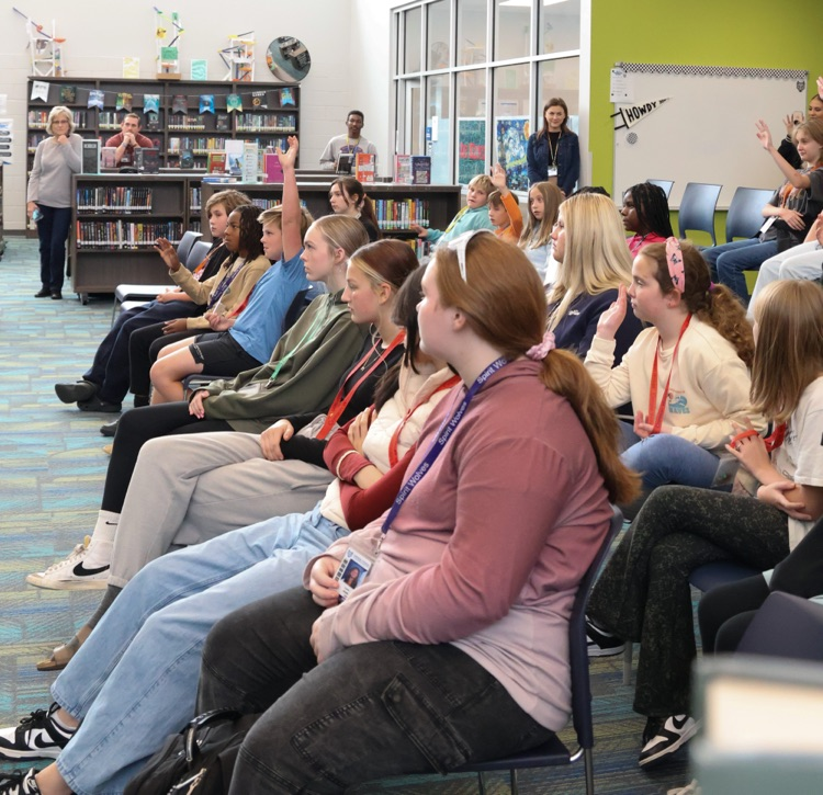 students listening to musician playing guitar 
