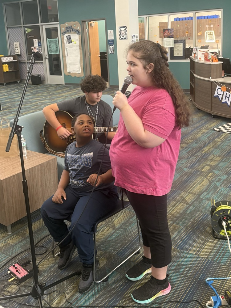 students listening to musician playing guitar 