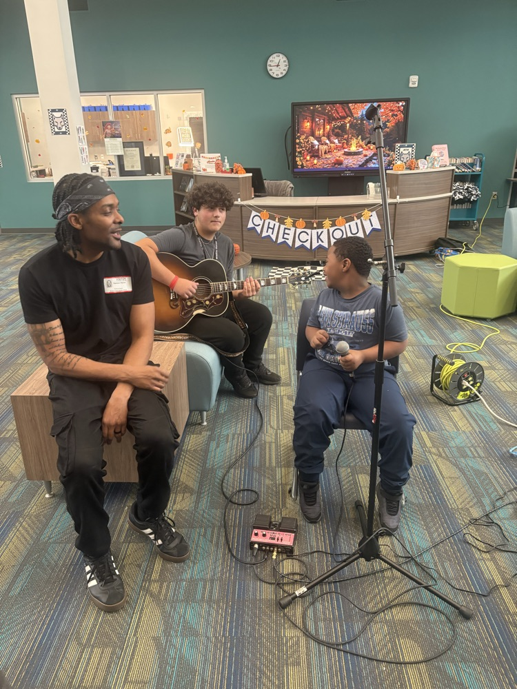 students listening to musician playing guitar 