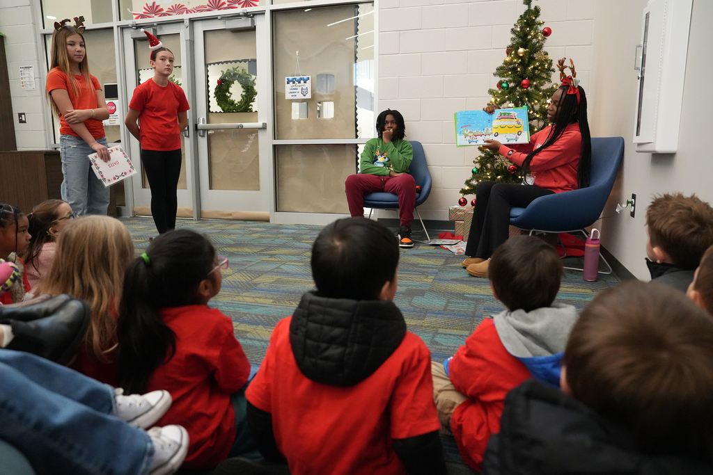 student reading to other students