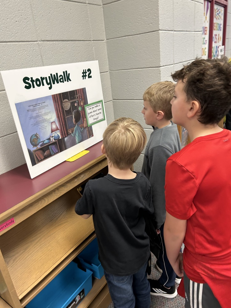 students reading StoryWalk signs