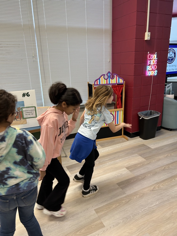 students reading StoryWalk signs