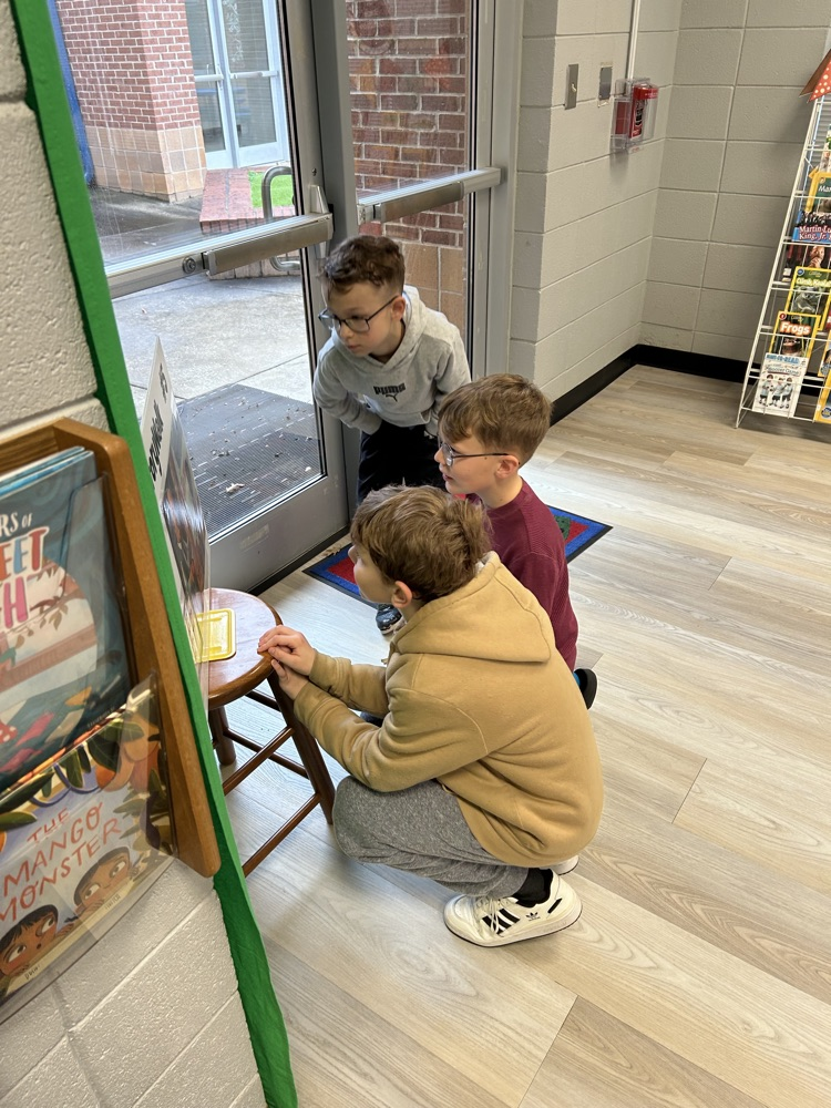 students reading StoryWalk signs