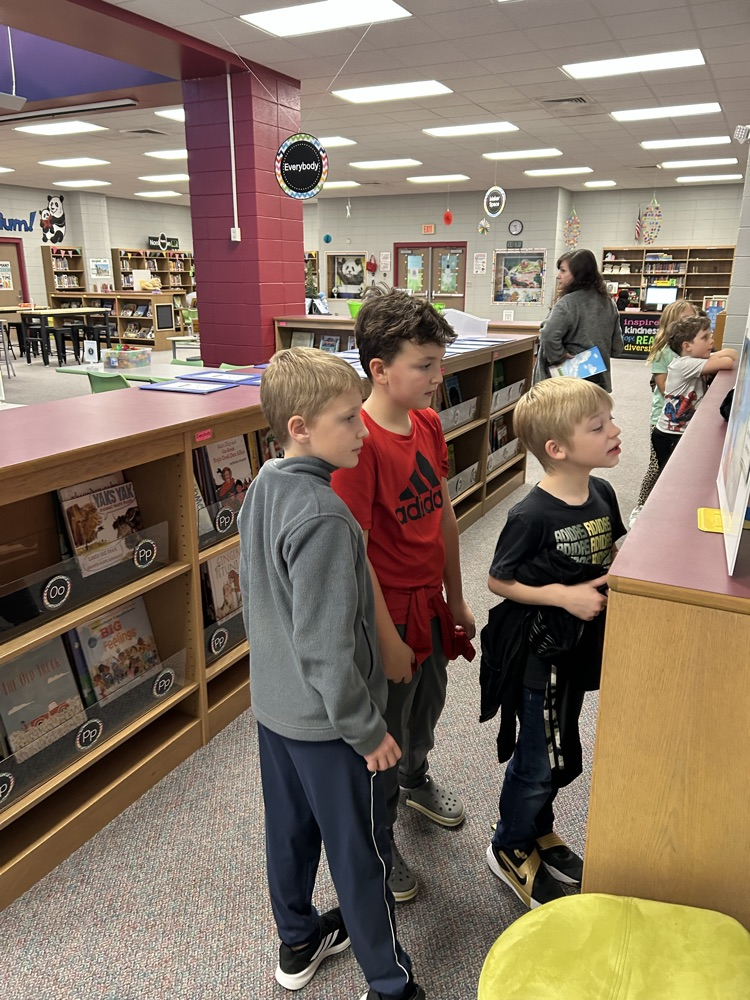 students reading StoryWalk signs