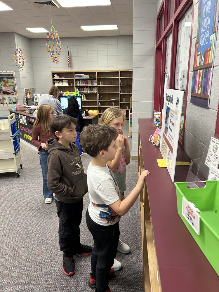 students reading StoryWalk signs